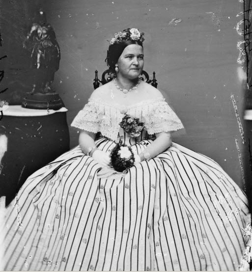 picture of Mary Todd Lincoln. A photo of Mrs Lincoln with bare shoulders, holding a bouquet of flowers.